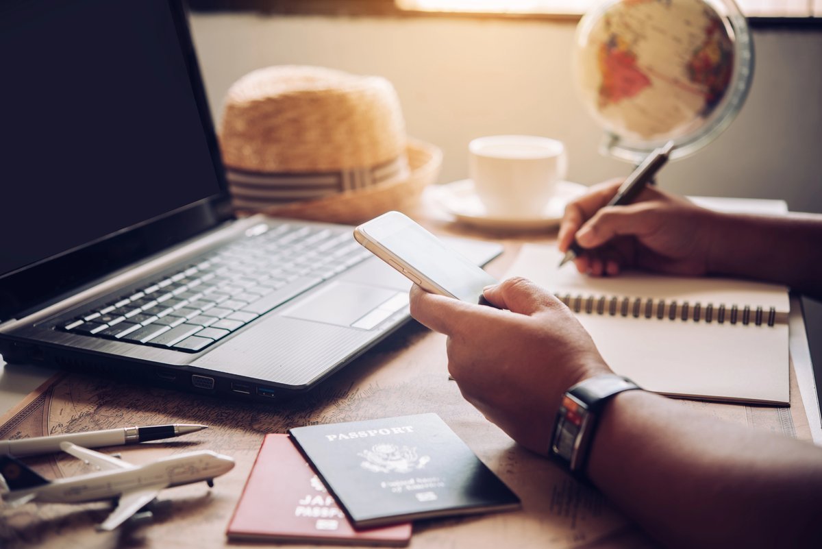 Planification d'un voyage au Canada sur mesure : passeports, carnet de notes et smartphone sur un bureau de voyageur