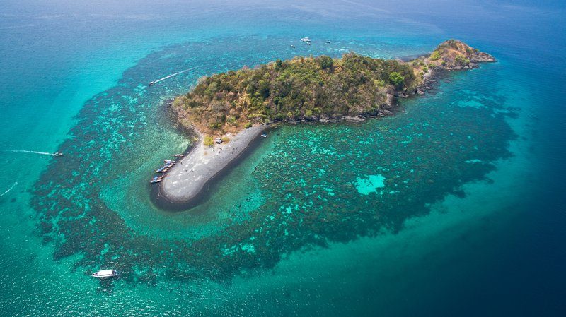 Vue aérienne de l’île de Koh Hin Ngam, connue pour ses plages de galets noirs et ses eaux turquoise.
