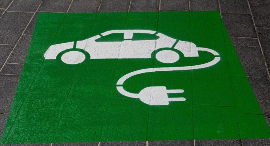 Signalisation verte au sol indiquant un espace dédié à la recharge des voitures électriques