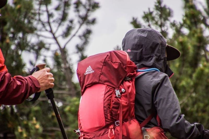 Deux personnes en randonnée avec des sacs à dos rouges dans les environs de Dolceacqua, Italie.
