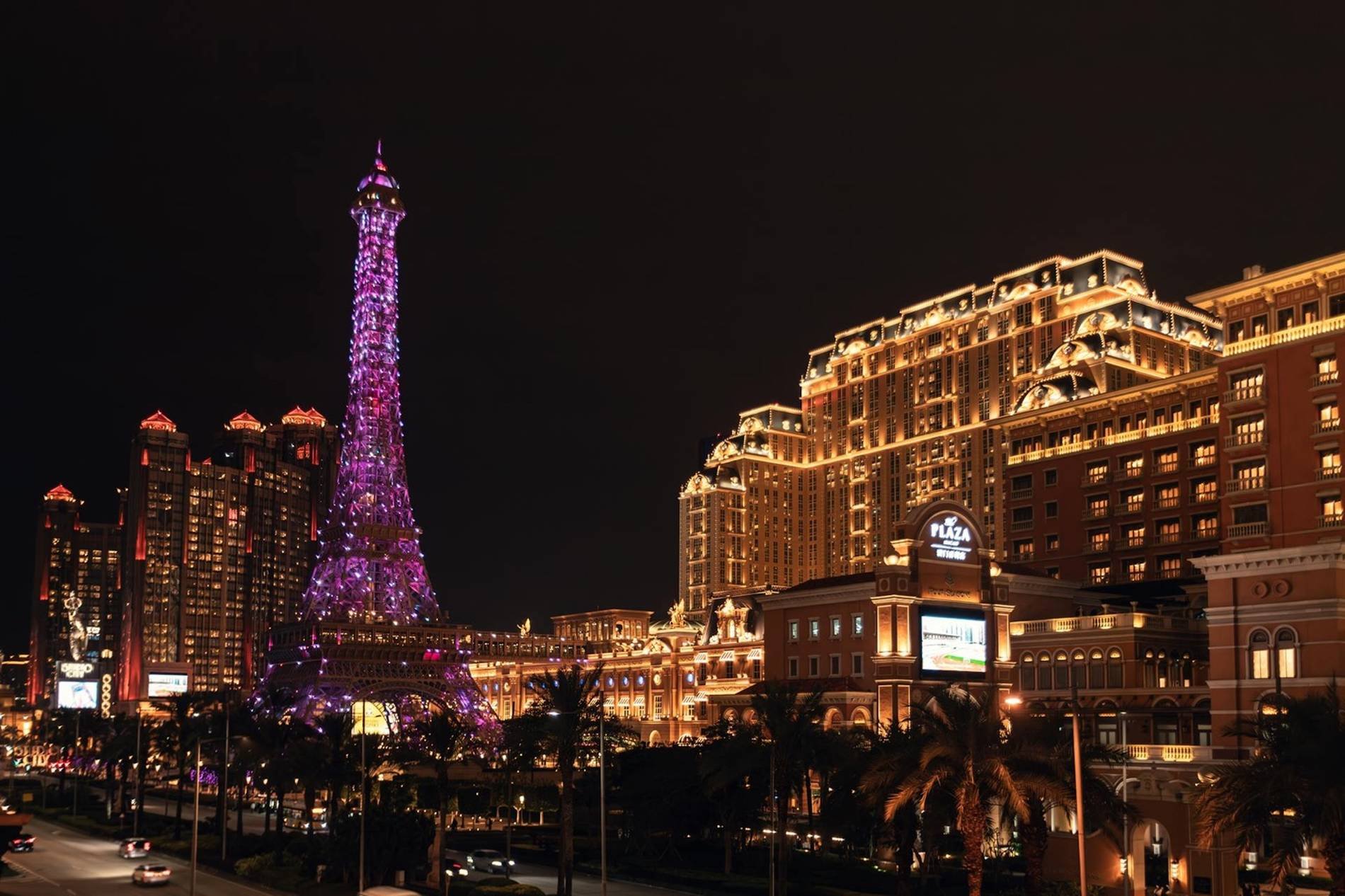 Réplique de la Tour Eiffel illuminée de nuit à Macao, Chine, entourée d’hôtels et de bâtiments luxueux.