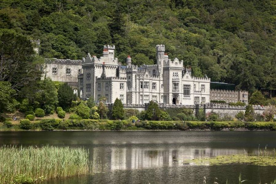 Vue majestueuse de l’abbaye de Kylemore, entourée de verdure et reflétée dans le lac voisin.