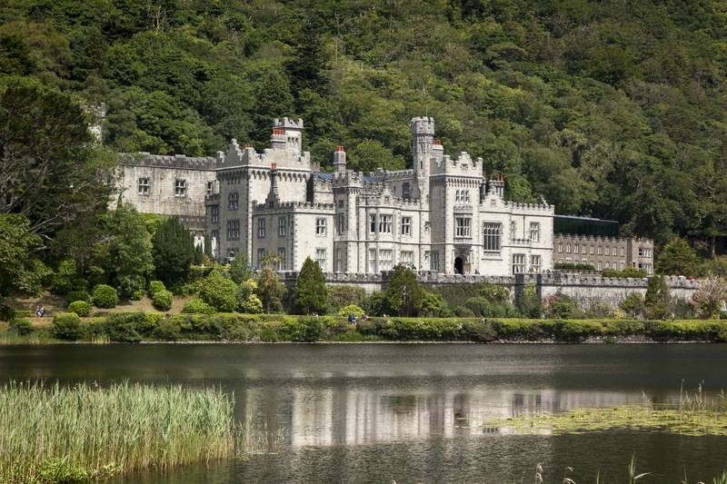 Vue majestueuse de l’abbaye de Kylemore, entourée de verdure et reflétée dans le lac voisin.