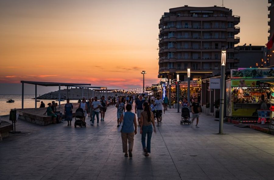 Promenade animée de Durrës en bord de mer au coucher du soleil.