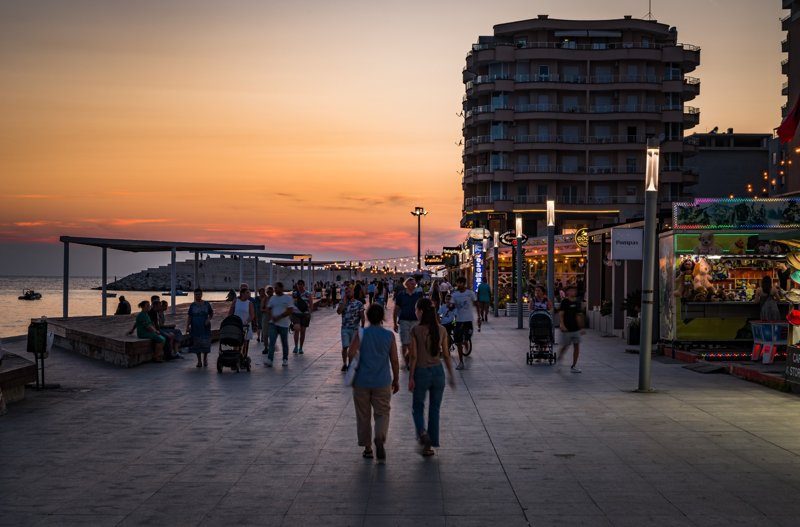 Promenade animée de Durrës en bord de mer au coucher du soleil.