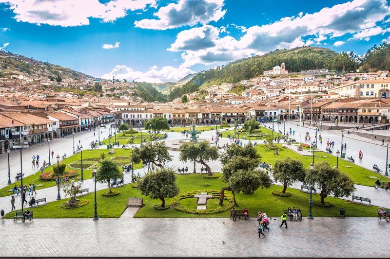 Place principale Plaza de Armas de Cusco, avec jardins, fontaine centrale, bâtiments coloniaux et collines en arrière-plan