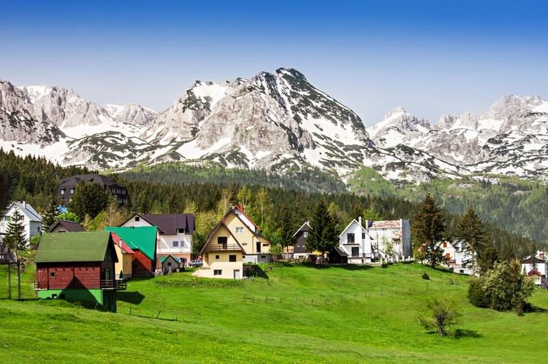 Maisons traditionnelles de Žabljak au pied des montagnes enneigées du parc national de Durmitor au Monténégro.