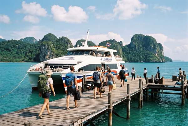 Passagers embarquant sur le ferry catamaran Lomprayah sur le ponton en bois de Koh Phangan, dans le golfe de Thaïlande.