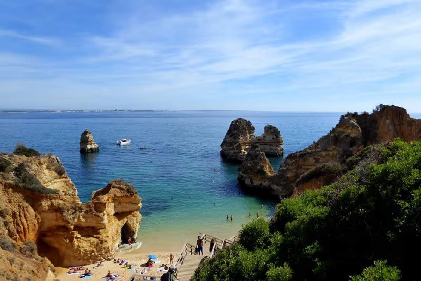 Plage de sable entourée de formations rocheuses spectaculaires avec une mer bleue à Lagos, Portugal.