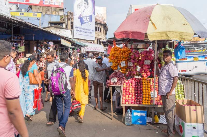 Marché de Pettah à Colombo avec étals de fruits colorés et foule animée.