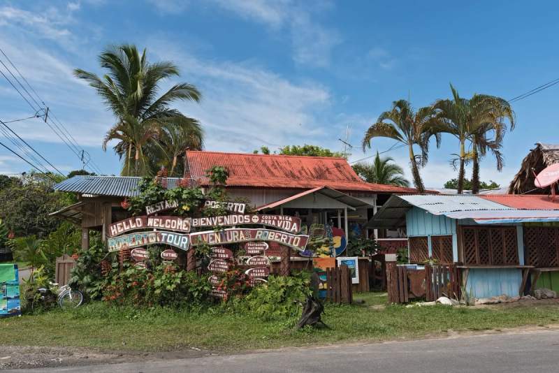 Façade colorée d'Aventuras Roberto à Puerto Viejo, accueillant les visiteurs avec des panneaux faits à la main.