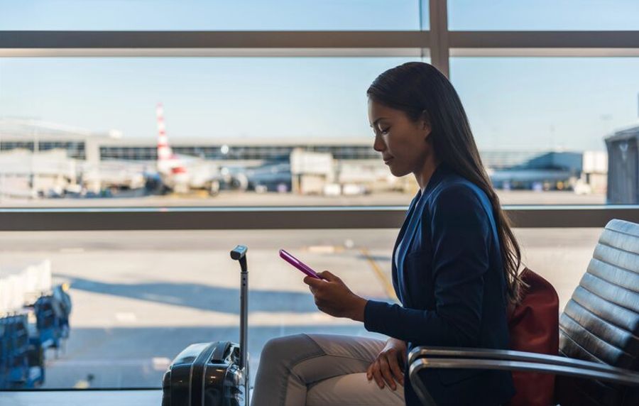Voyageuse consultant son smartphone dans un terminal d