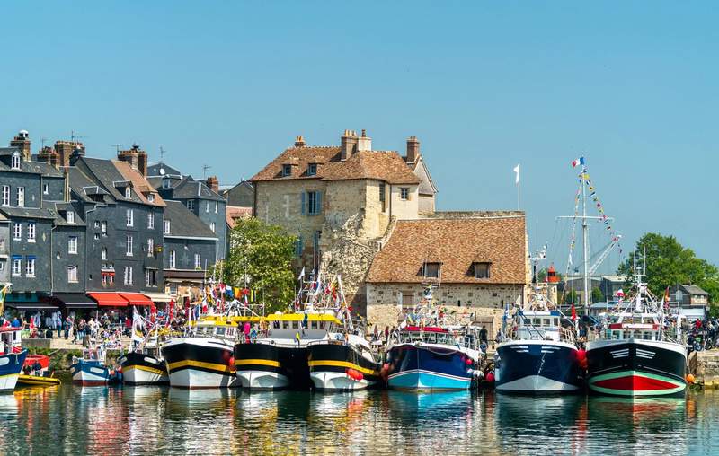 Bateaux de pêche amarrés dans le Vieux-Bassin d'Honfleur, avec les maisons normandes à ardoises du quai en arrière-plan