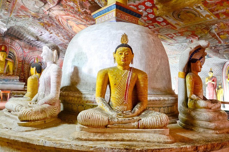 Intérieur des grottes de Dambulla, avec des statues de Bouddha et des peintures murales bouddhistes vieilles de plusieurs siècles.