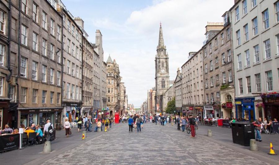 Ruelle pavée de la Royal Mile avec la Tron Kirk et ses hauts immeubles de pierre grise typiques de l'Old Town d'Édimbourg.