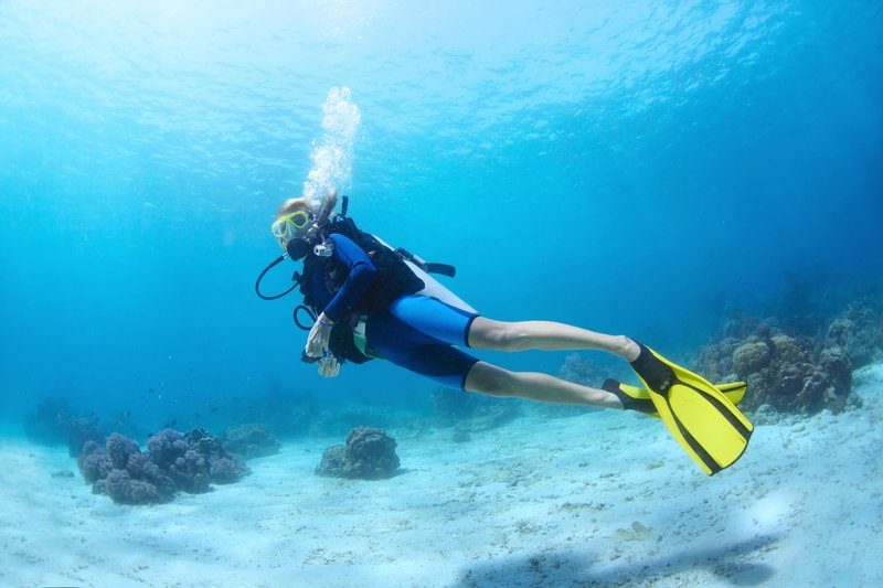 Plongeuse équipée explore les fonds marins clairs et coralliens des îles Perhentian.
