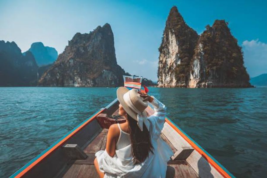 une femme asiatique voyageuse se détend et voyage sur un bateau thaïlandais à longue queue dans le barrage de ratchaprapha au parc national de khao sok surat thani thaïlande - voyage photos et images de collection