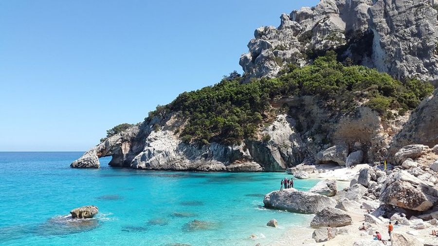 Plage de Cala Goloritzé en Sardaigne avec eau turquoise et falaises.