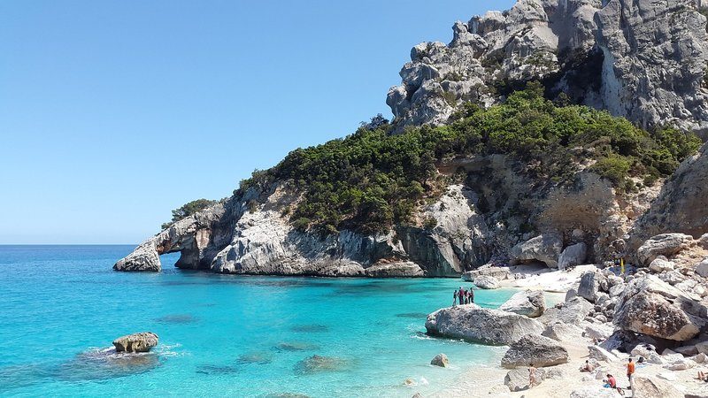Plage de Cala Goloritzé en Sardaigne avec eau turquoise et falaises.