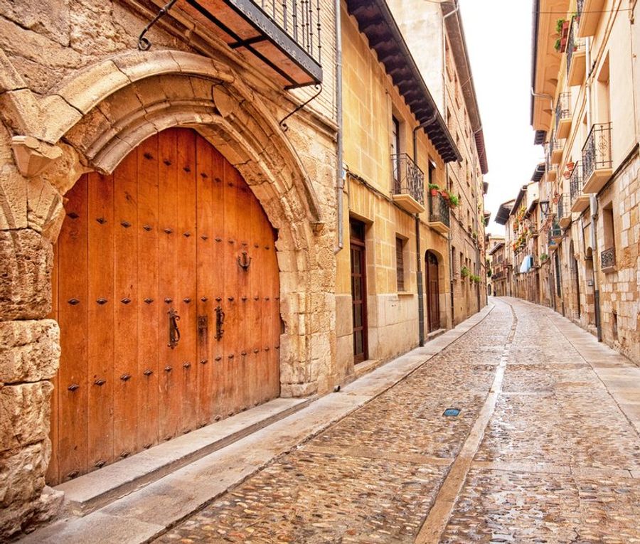 Ruelle pavée étroite dans la vieille ville de Bilbao, bordée de maisons historiques en pierre.