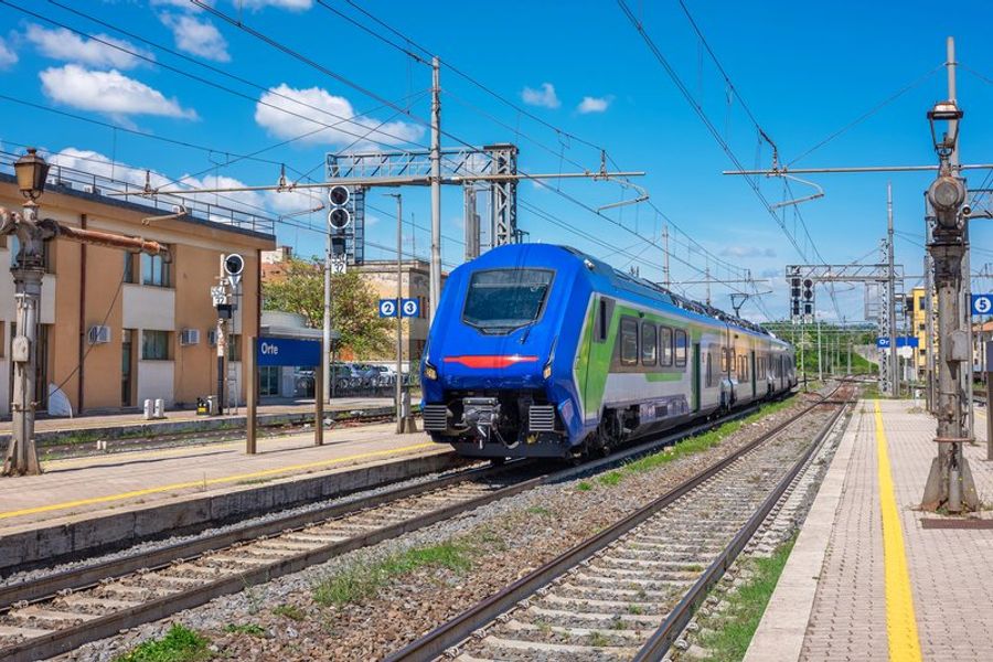 Un train Italo EVO bleu et vert entre en gare d