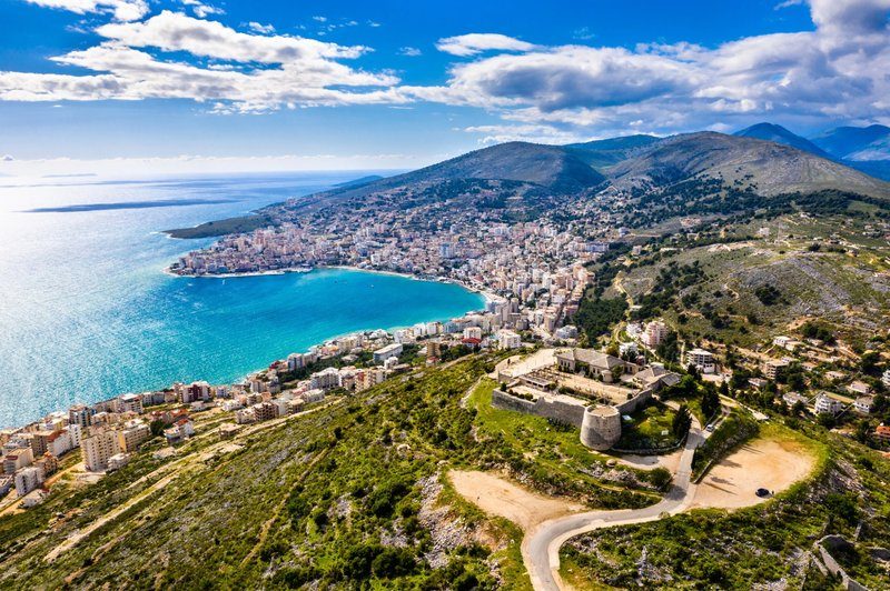 Vue aérienne de Saranda en Albanie, baie turquoise et ville côtière entourée de montagnes