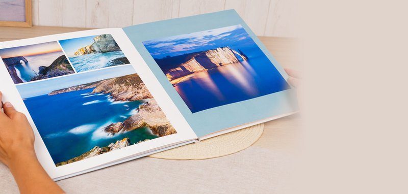Un livre photo ouvert montrant des photos de paysage côtier avec des vues de falaises et de plages.