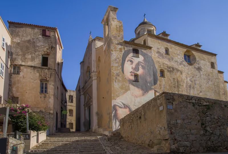 Façade d'une église avec une fresque à Calvi.