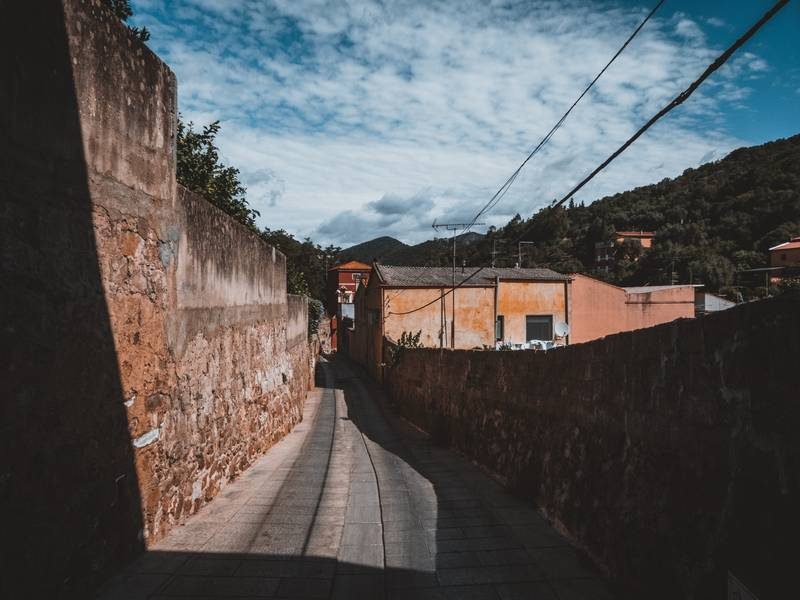 Une ruelle avec des murs en pierre.