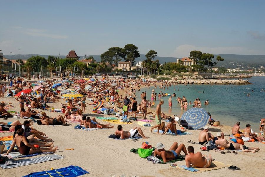 Plage de La Ciotat bondée avec des vacanciers profitant du soleil et de la mer.