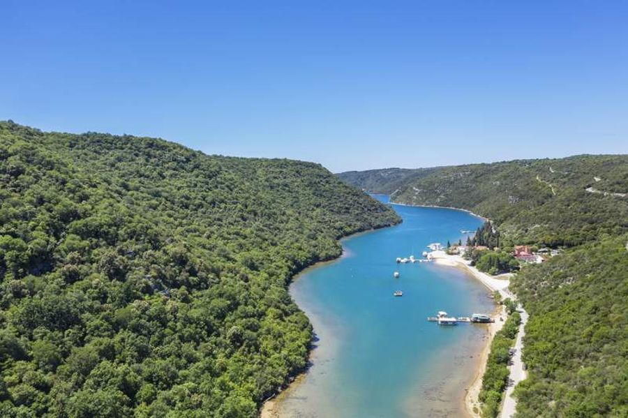 Vue aérienne du fjord de Lim, entouré de collines verdoyantes et bordé par des eaux turquoise.