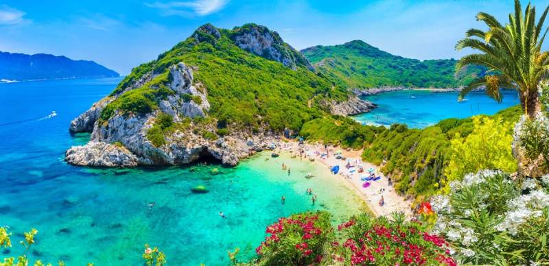Vue panoramique de Porto Timoni à Corfou, présentant ses deux criques pittoresques entourées de végétation et d'eaux turquoise parfaites pour la baignade.
