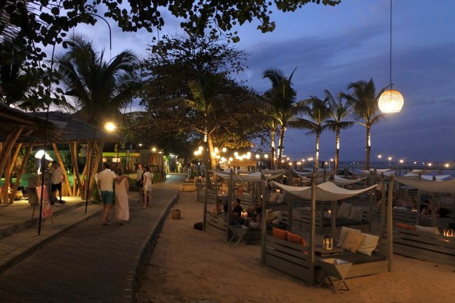 Balade nocturne le long de la promenade pavée en bord de mer à Sanur, Bali.