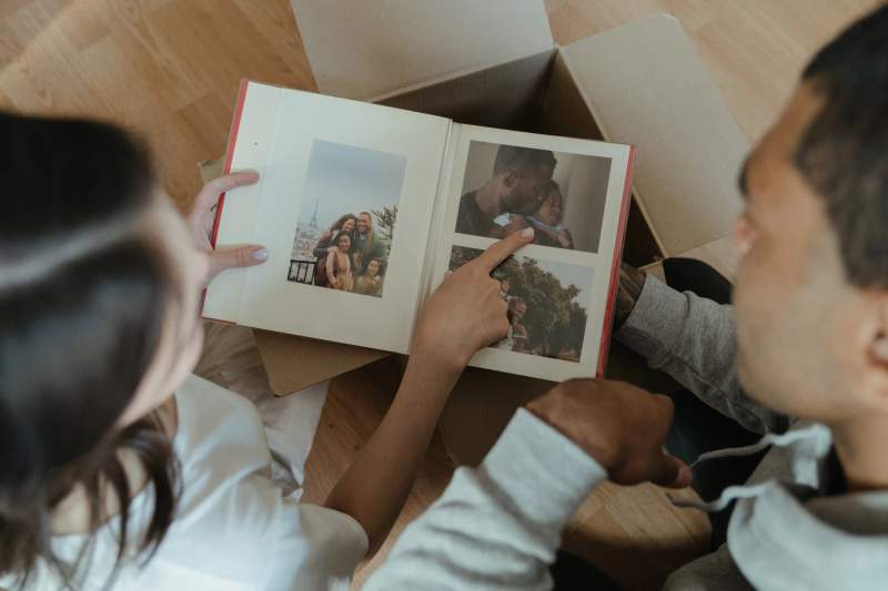 Un couple en train de regarde leur livre de photos de voyage