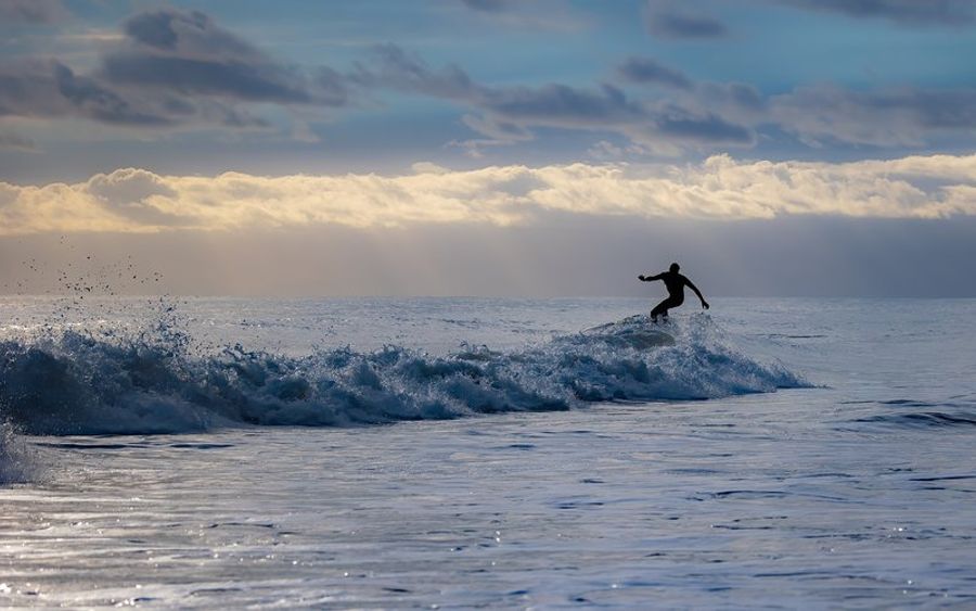 Un surfeur attrapant une vague à Porto, montrant les conditions idéales pour le surf sur les plages de la région.