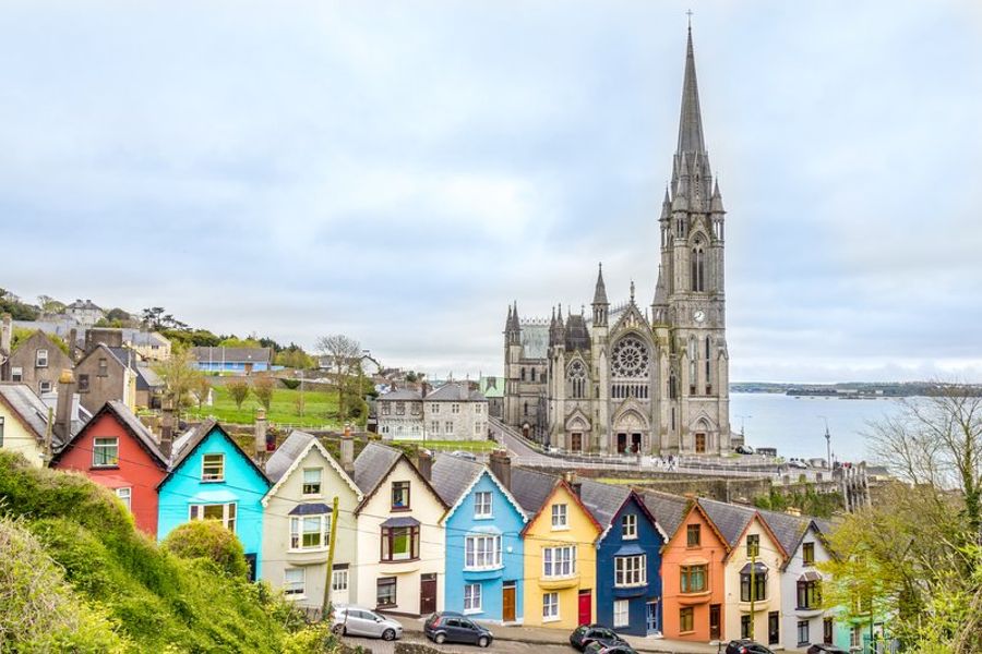 Vue pittoresque de Cobh avec ses maisons colorées et sa cathédrale dominant le port.