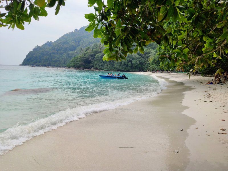Plage de Turtle Beach avec sable blanc et mer calme, encadrée par une végétation dense sur Pulau Besar.