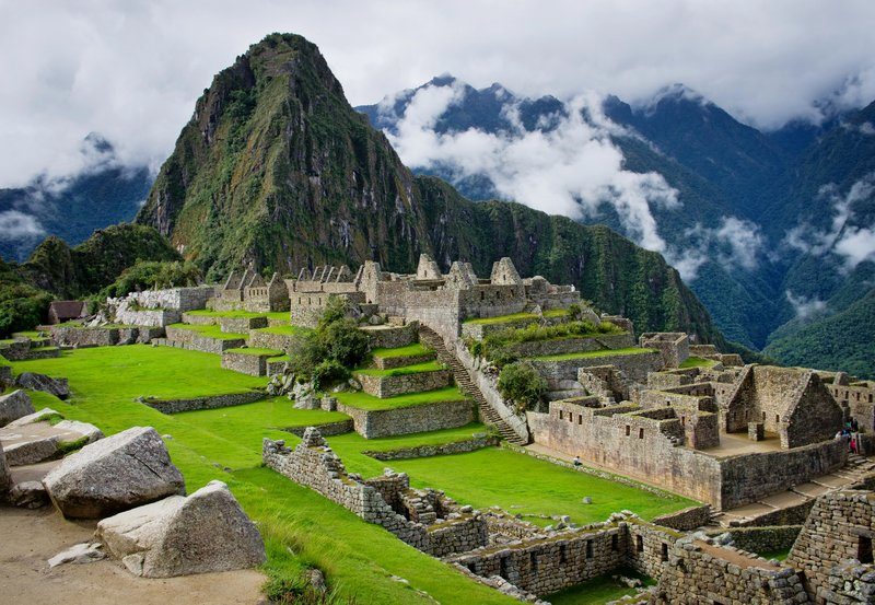 Panorama du Machu Picchu, ancienne cité inca entourée de montagnes et de nuages, site emblématique du Pérou classé UNESCO