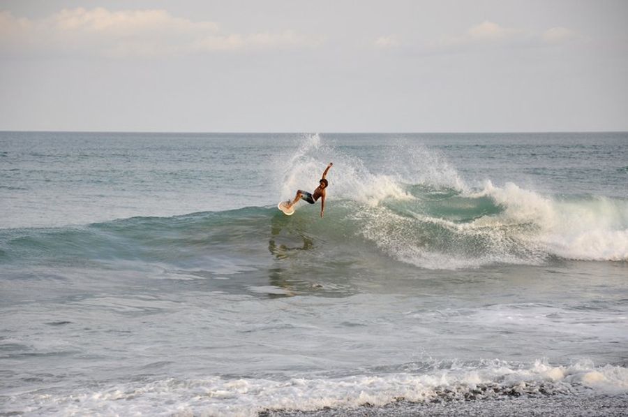 Surfeur réalisant une figure sur une vague à Jacó.