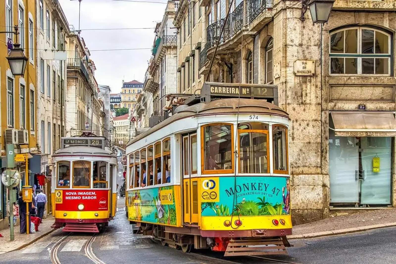 Tramways traditionnels jaunes circulant dans les rues étroites du centre historique de Lisbonne, au Portugal.