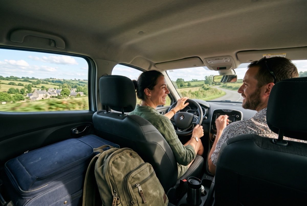 Deux voyageurs partagent la route en voiture sur les petites routes de Bretagne avec leurs bagages