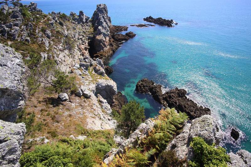 Falaises rocheuses de la presqu'île de Crozon en Bretagne surplombant une crique aux eaux turquoise cristallines