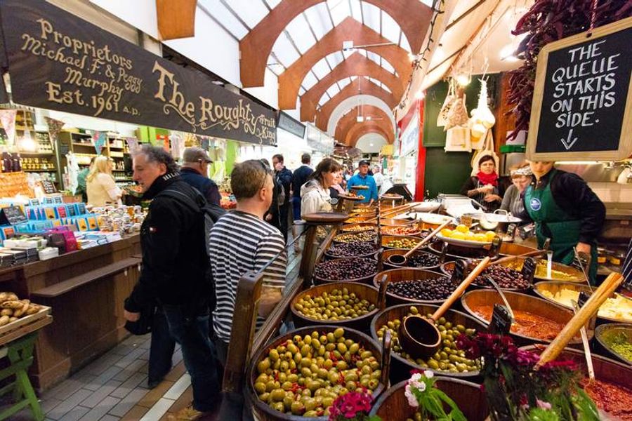 Intérieur animé de l’English Market à Cork, avec des étals colorés remplis de produits locaux.