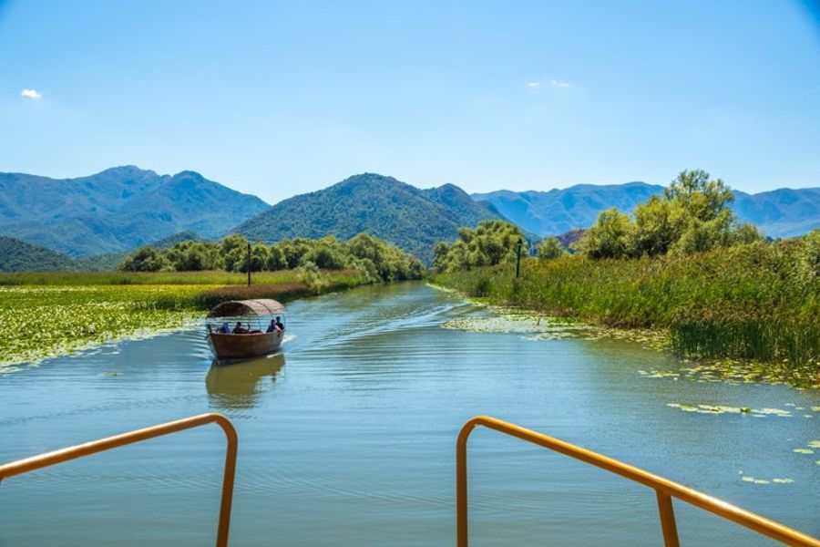 Lac Skadar près de Shkodër, le plus grand lac des Balkans, avec ses eaux calmes et ses montagnes en arrière-plan.