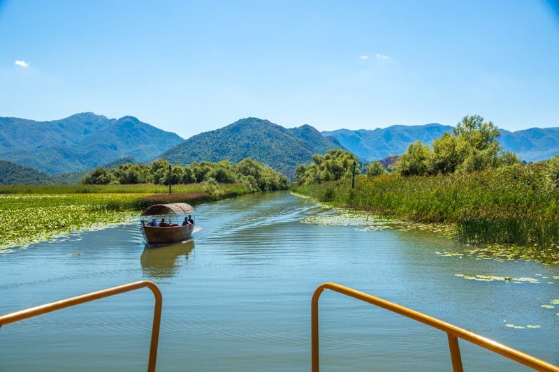 Lac Skadar près de Shkodër, le plus grand lac des Balkans, avec ses eaux calmes et ses montagnes en arrière-plan.