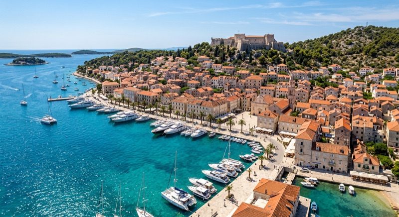 Vue panoramique sur le port historique de Hvar en Croatie avec ses toits rouges et eaux turquoise.