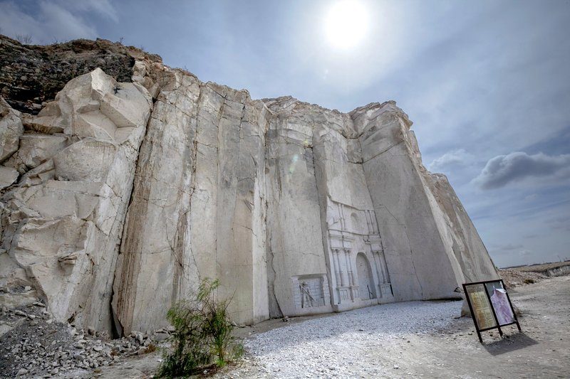 Carrière de sillar près d’Arequipa avec une façade sculptée dans la roche volcanique sous un ciel ensoleillé.