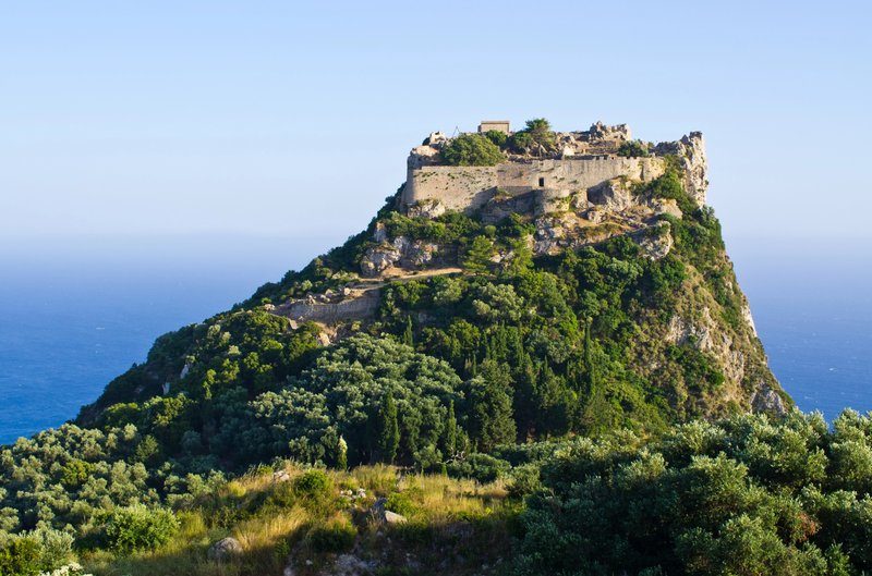 Ruines de la forteresse Angelokastro perchées sur une colline, surplombant la mer Ionienne et les forêts environnantes.