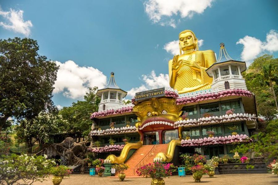 Statue dorée de Bouddha au temple de Dambulla, un site religieux emblématique du Sri Lanka.