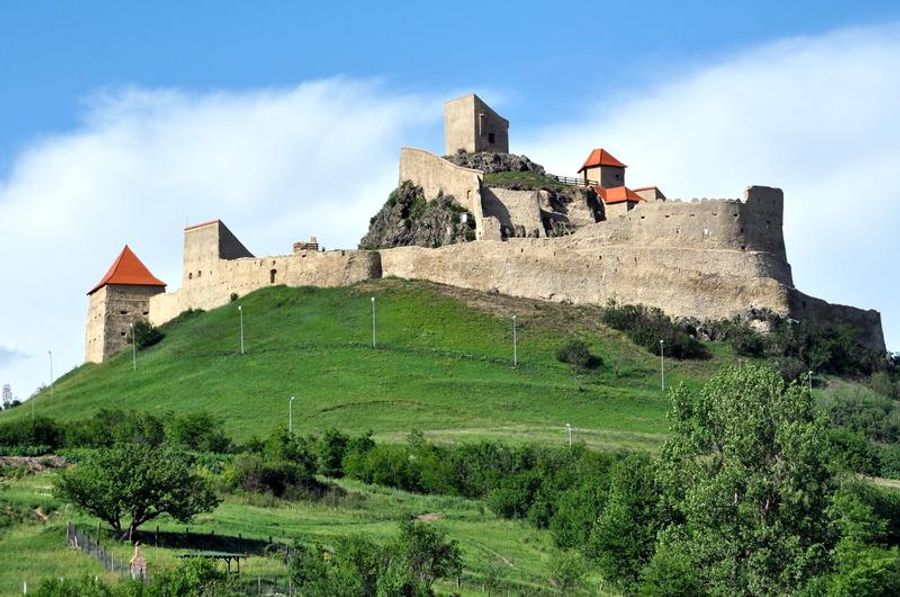 Château de Rupea perché sur une colline verdoyante.